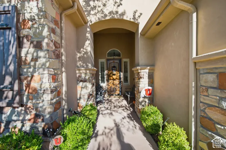Arched entryway with a wood-finish front door, accented by stone veneer and stucco exterior finishes
