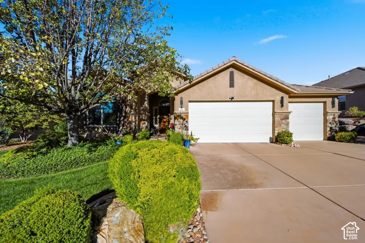 Stucco exterior with stone accents, featuring an arched entry, a two-car garage, and an additional one-car garage