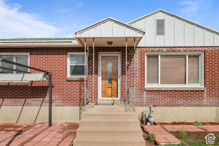 Brick exterior with a gabled roofline, covered front entry, and concrete steps
