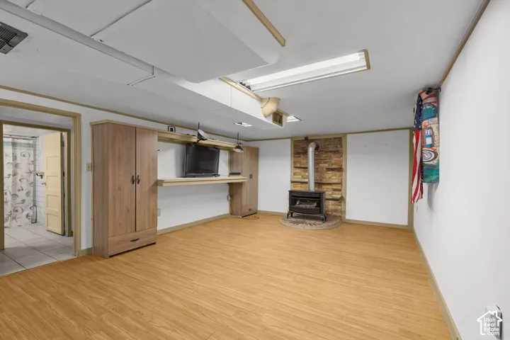 Wood-finish flooring with a wood-burning stove and brick-look surround