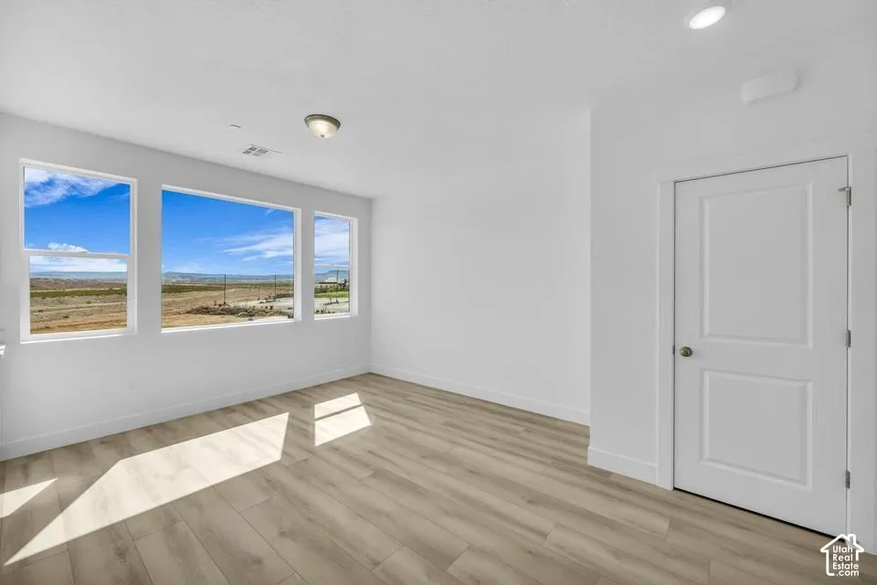 Bright interior with multiple windows, wood-finish flooring, and a two-panel door