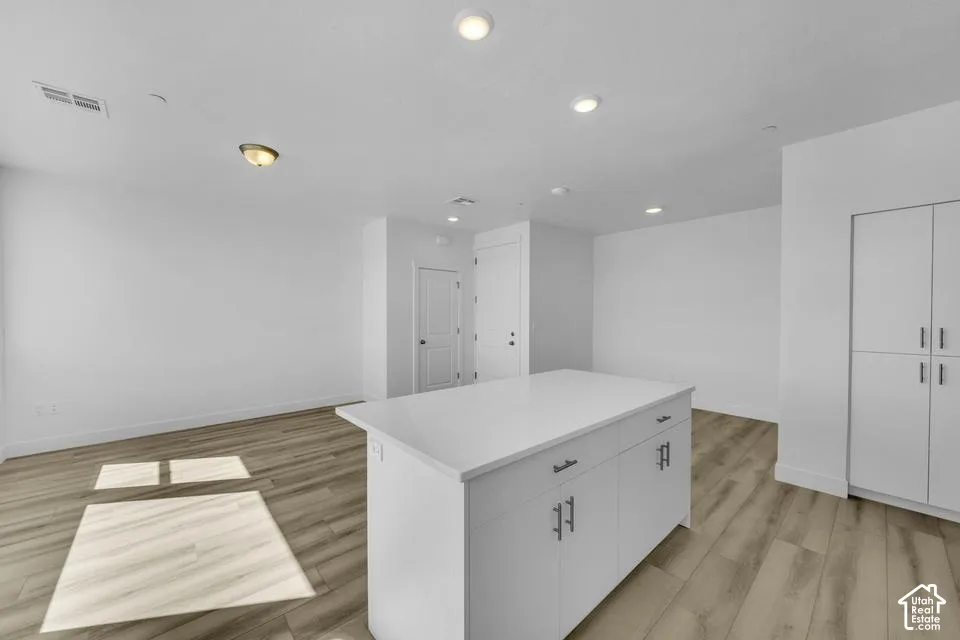 Kitchen island featuring a solid surface countertop and integrated cabinetry
