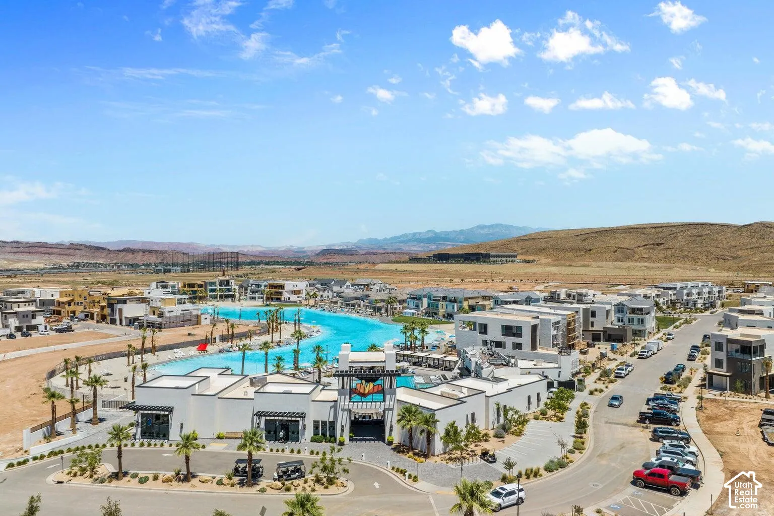 Expansive community featuring a large artificial lagoon, surrounding residential structures, and established roadways