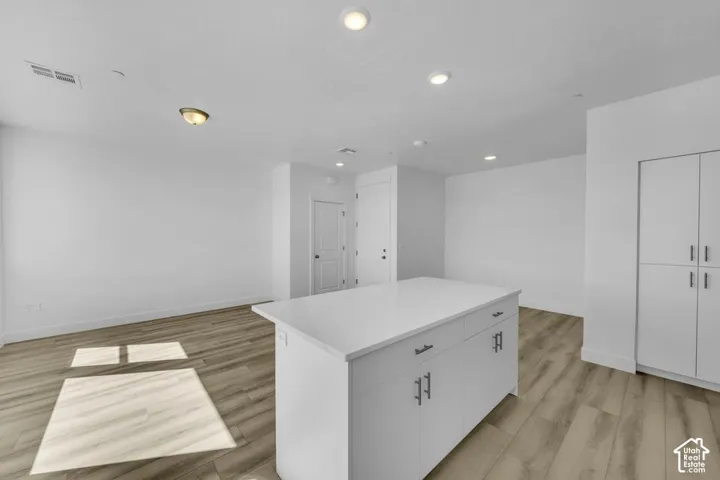 Kitchen island featuring a solid surface countertop and integrated cabinetry