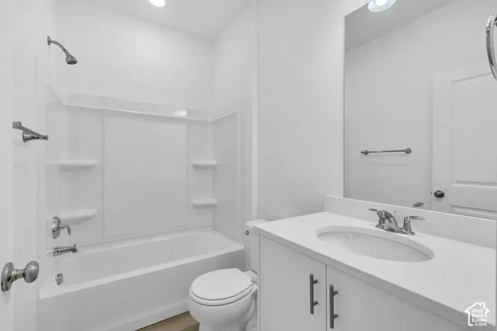 White vanity with a neutral countertop and integrated sink, chrome faucet, and a large wall-mounted mirror