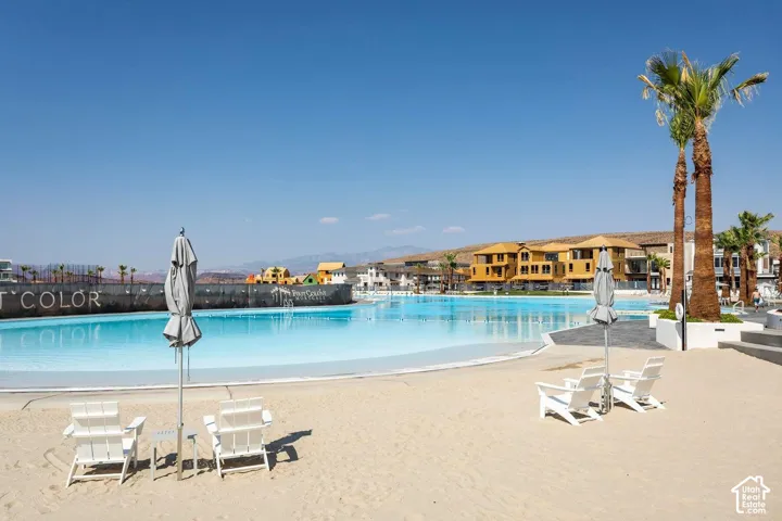 Expansive blue lagoon bordered by a sandy beach and mature palm trees