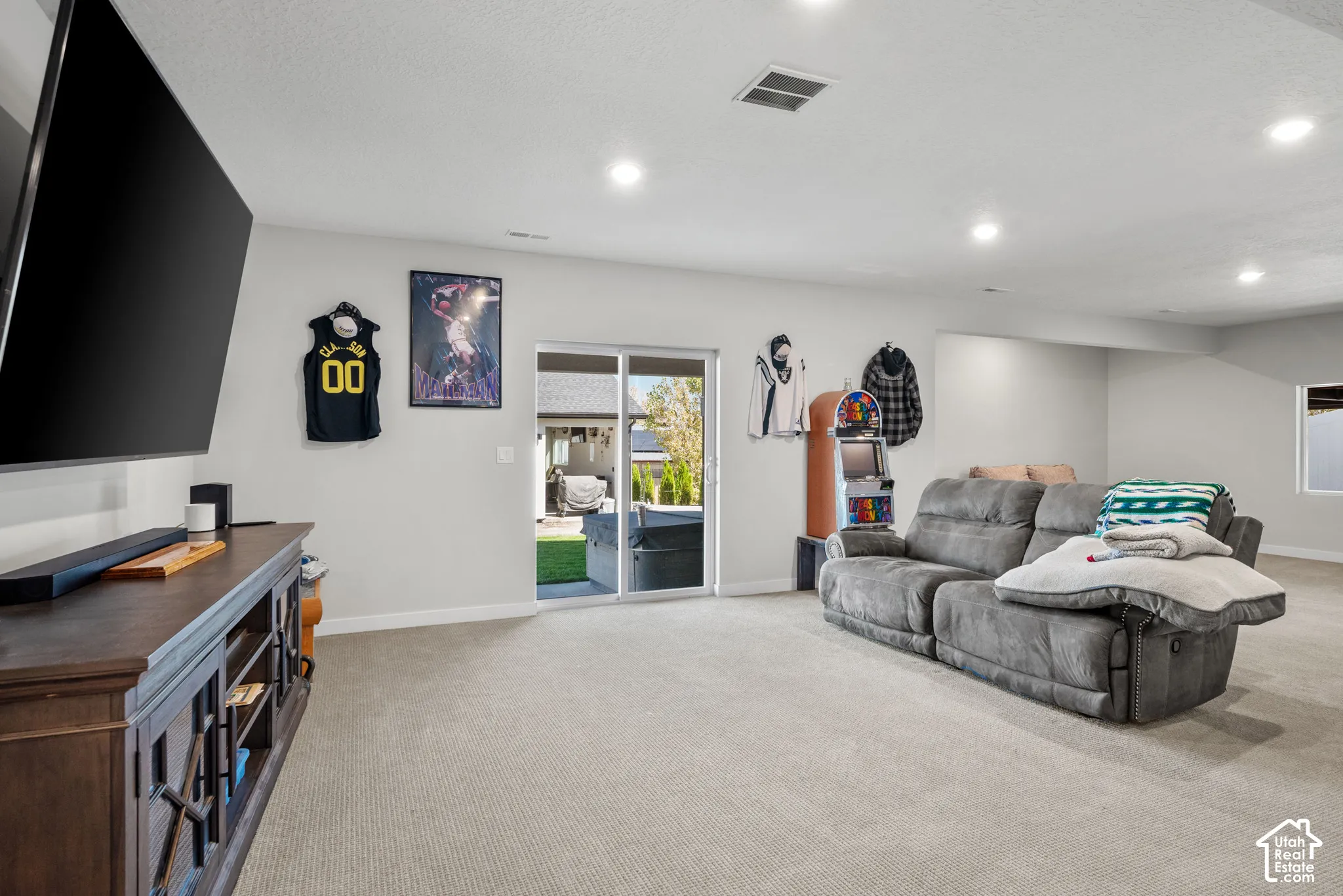 Carpeted flooring, recessed lighting, white painted walls, and sliding glass door access to the exterior