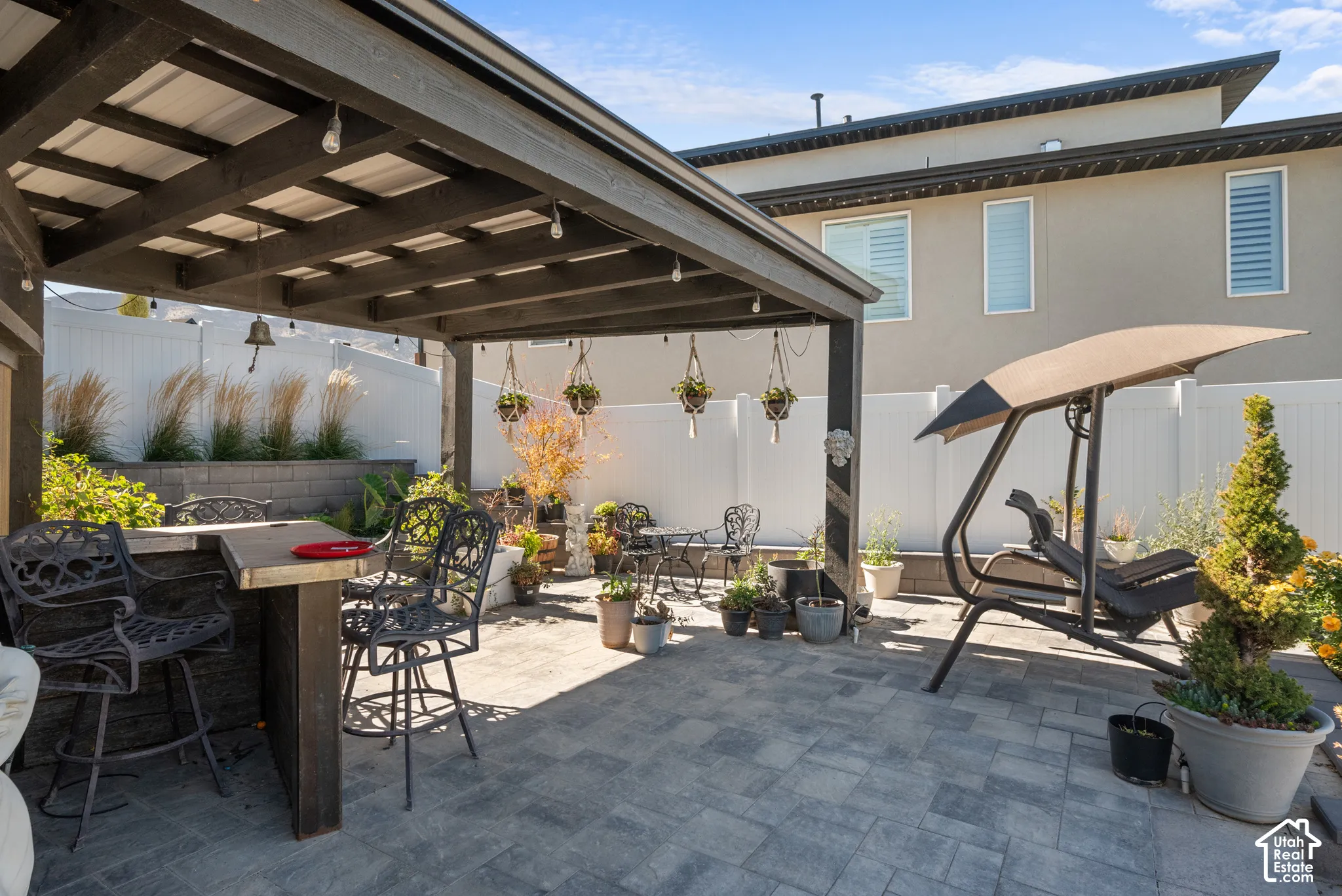Paved patio with an integrated pergola, built-in bar, and perimeter privacy fencing