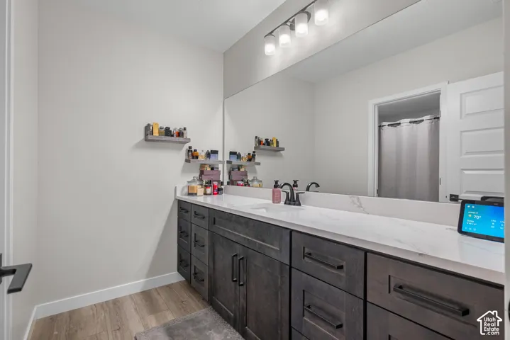 Dual vanity with dark wood-finish cabinetry, white countertop, and integrated sinks
