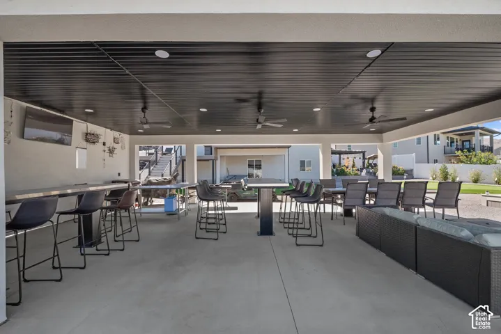 Expansive covered patio with concrete flooring, recessed lighting, and integrated ceiling fans