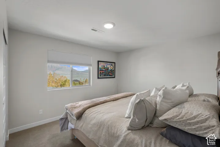 Recessed ceiling lighting, wall-to-wall carpeting, and a window with a mountain and lake backdrop