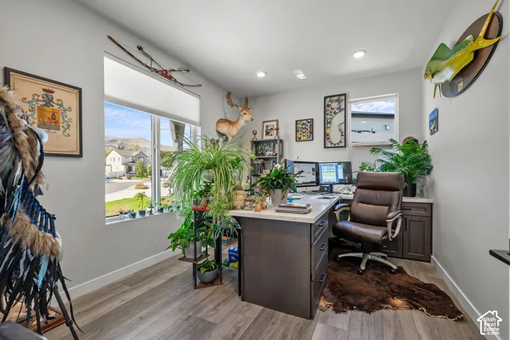 Recessed lighting, wood-finish flooring, and multiple windows provide ample illumination