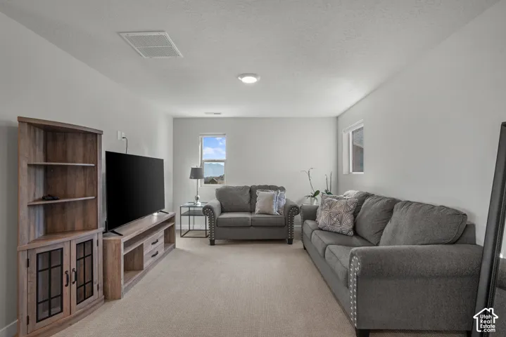 Recessed ceiling lighting, multiple windows, light-toned carpeting, and neutral wall tones