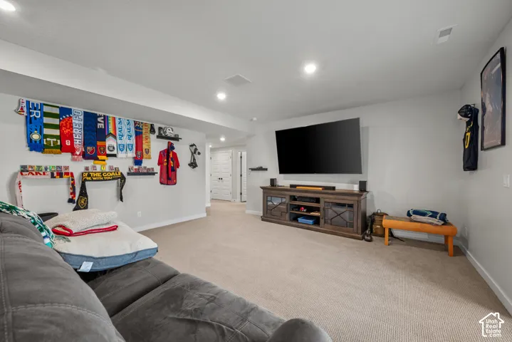 Recessed lighting, light-toned carpeting, and light-colored walls