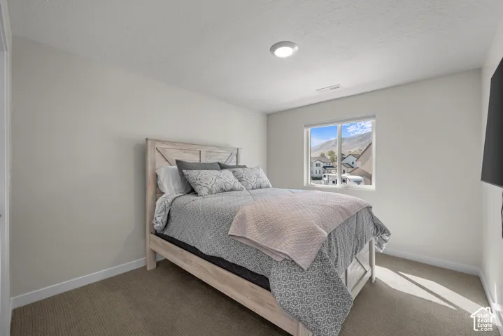 Recessed ceiling light, neutral wall color, carpeted flooring, and a large window