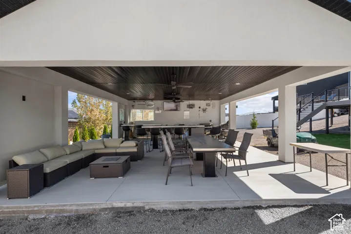 Covered outdoor patio with a dark wood-finish ceiling, recessed lighting, and a built-in bar