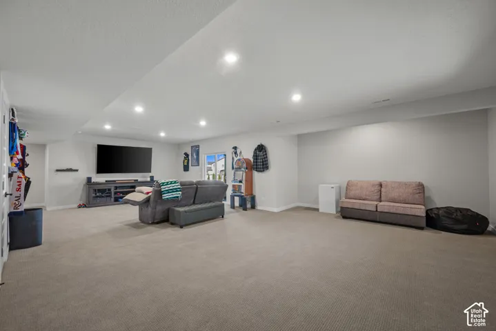 Spacious room featuring neutral carpeting, recessed lighting, and light-toned walls