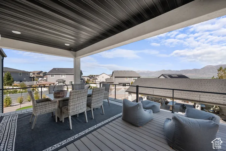 Covered outdoor deck featuring composite decking, cable railing, and recessed lighting
