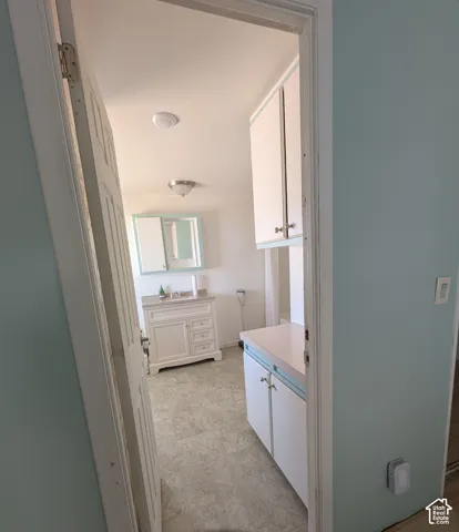 Primary Full Bathroom featuring a single vanity with a white cabinet, wall-mounted medicine cabinet, overhead light fixture/fan, and light-toned flooring.