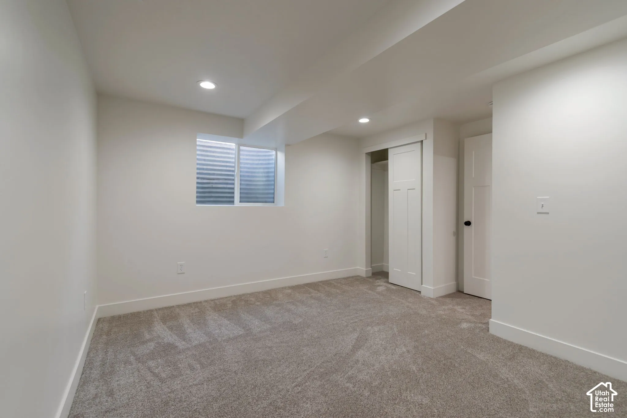 Wall-to-wall carpeting, recessed lighting, and a window with blinds