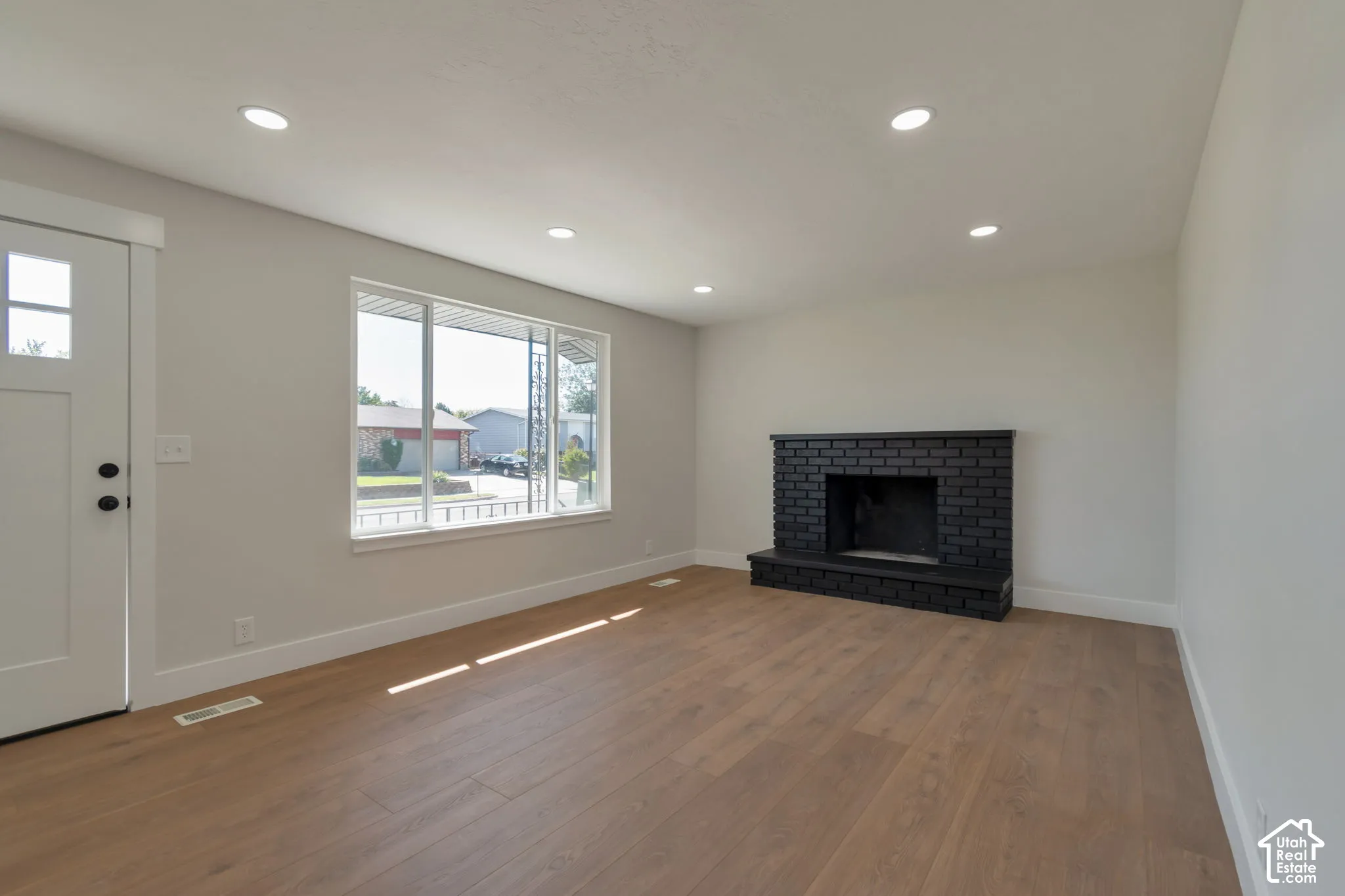 Warm wood-finish flooring with recessed lighting