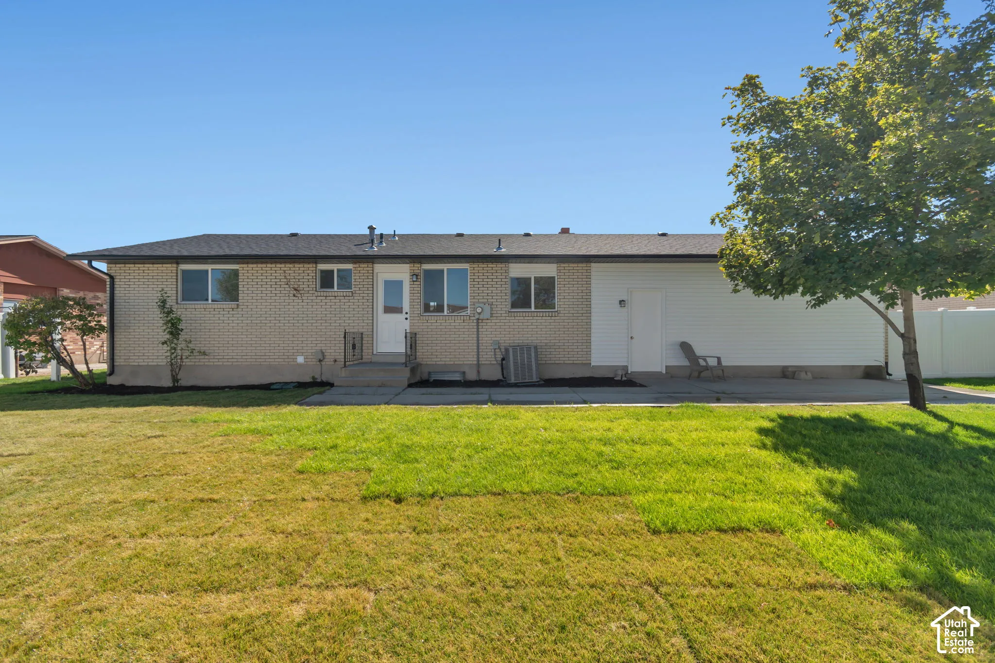 Backyard with a patio, manicured lawn, concrete patio, and mature trees