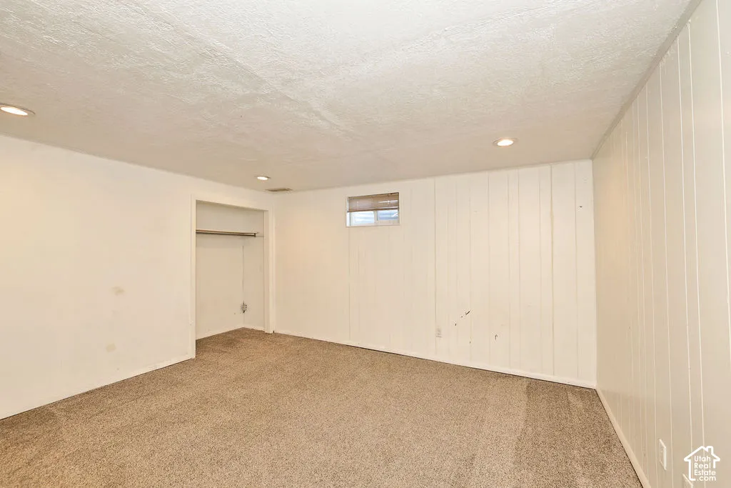 Recessed lighting, textured ceiling, wall-to-wall carpeting, window, and built-in closet