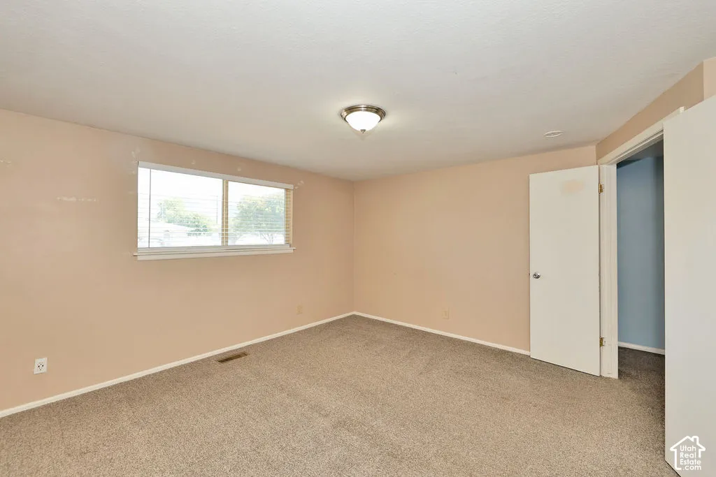 Carpeted flooring, neutral wall tones, and a double-paned window