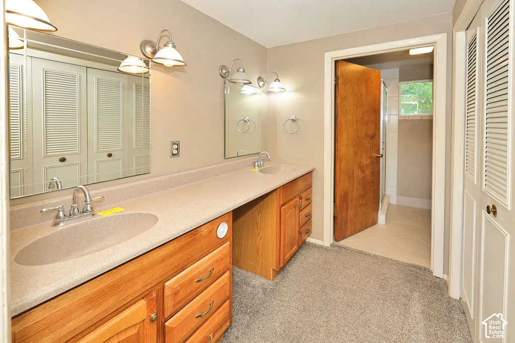 Dual vanity with integrated sinks, wood-finish cabinetry, and two wall-mounted light fixtures