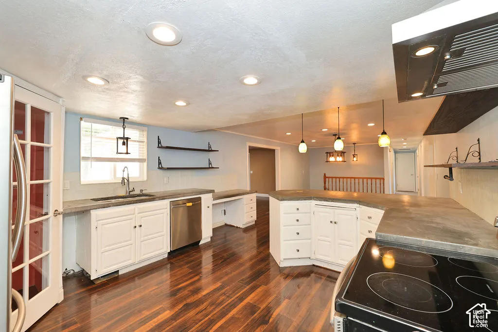 Kitchen featuring wood-finish flooring, white cabinetry, integrated stainless steel dishwasher, recessed lighting, and pendant lighting