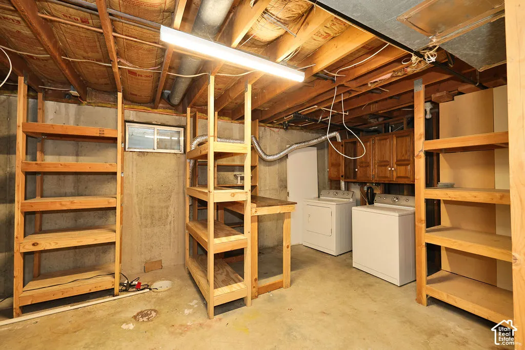 Exposed ceiling joists, concrete flooring, built-in wooden shelving, upper cabinetry, and a window