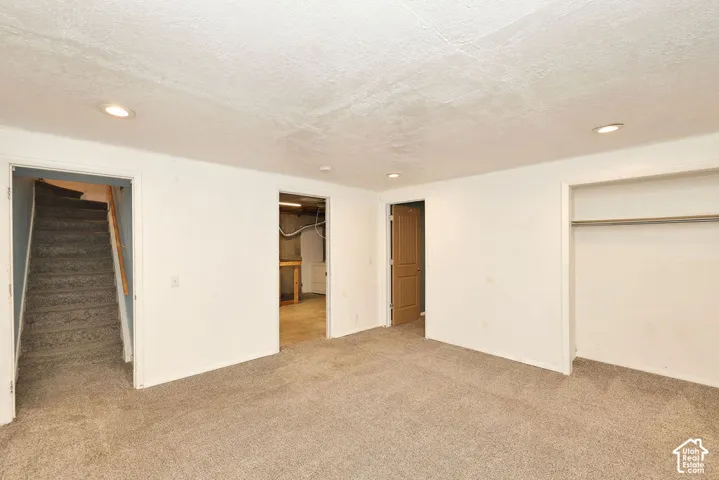 Wall-to-wall carpeting with recessed lighting, a built-in closet, and light wood-paneled doors