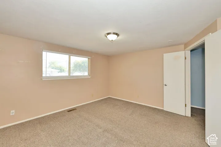Carpeted flooring, neutral wall tones, and a double-paned window