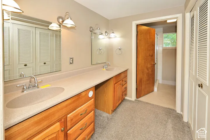 Dual vanity with integrated sinks, wood-finish cabinetry, and two wall-mounted light fixtures