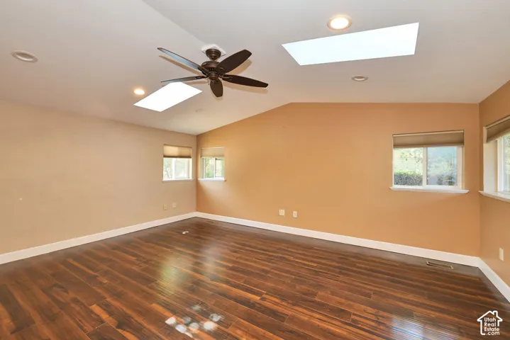 Vaulted ceiling featuring a ceiling fan and dual skylights