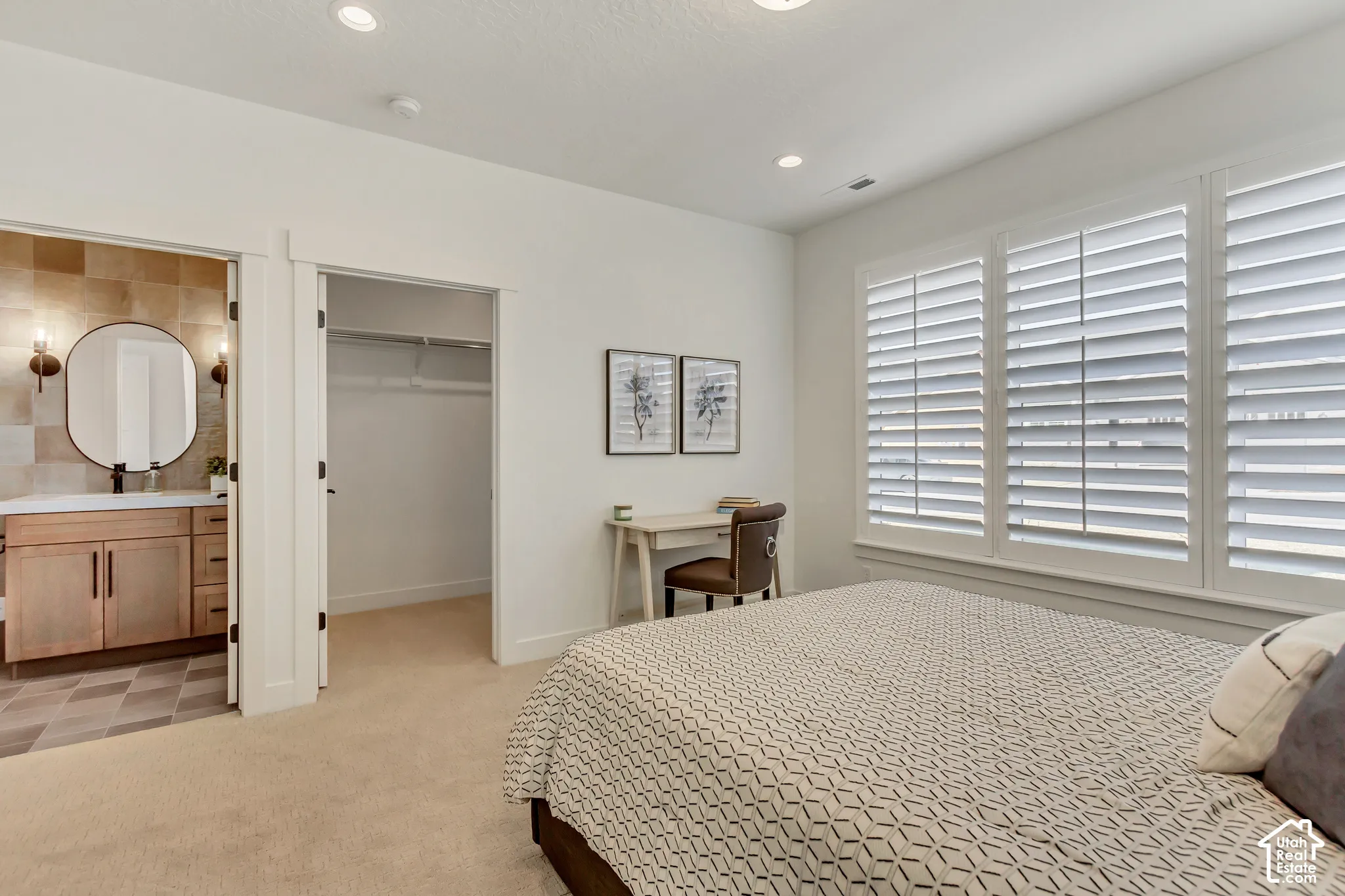 Recessed lighting, plantation shutters, built-in closet storage, and a bathroom entry with a wood-finish vanity and tiled floor