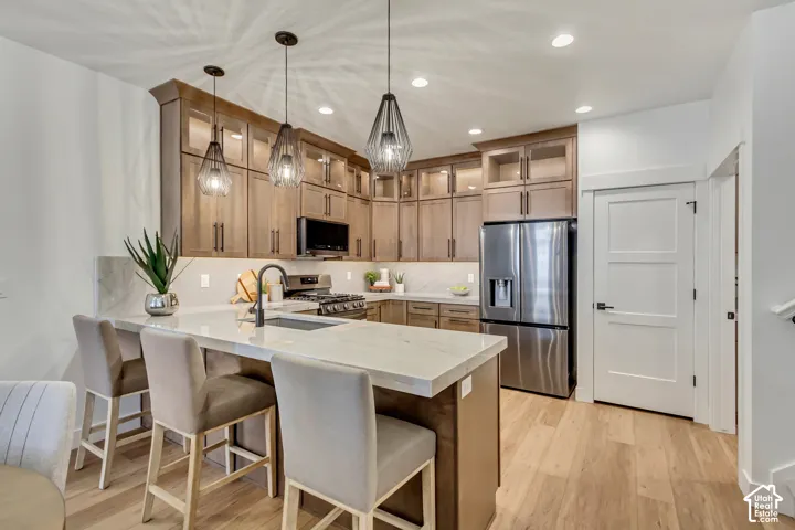 Wood-finish flooring, recessed lighting, and a stainless steel refrigerator