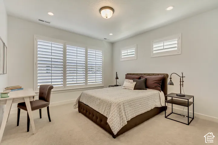 Recessed lighting, central ceiling fixture, and multiple windows with plantation shutters