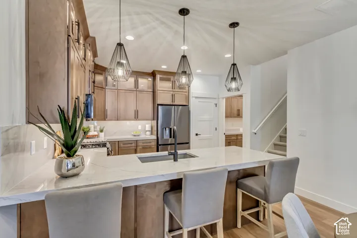 Gourmet kitchen with an expansive island, integrated sink, and three pendant light fixtures