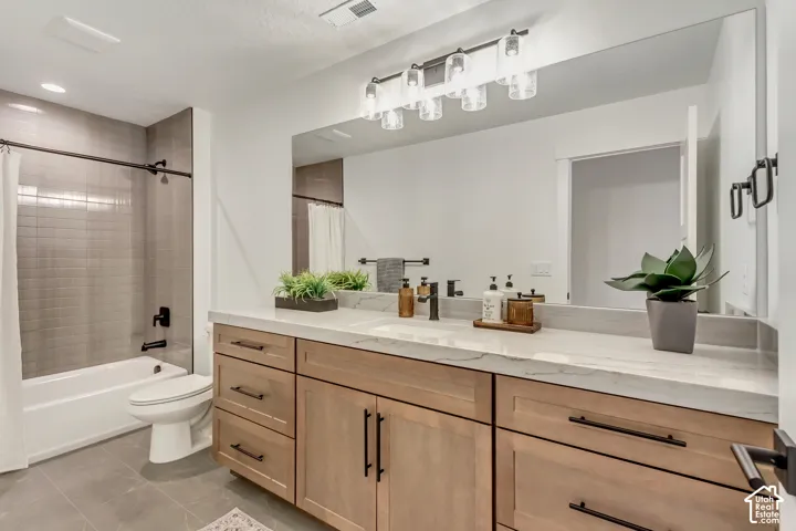 Wood-finish double vanity with undermount sinks, stone countertop, and matte black hardware