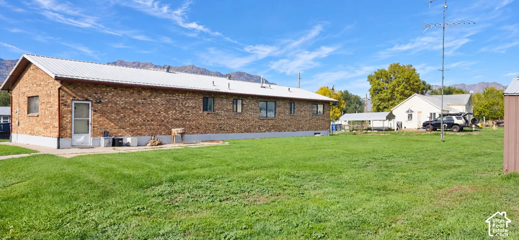 Brick exterior with a metal roof and a spacious lawn