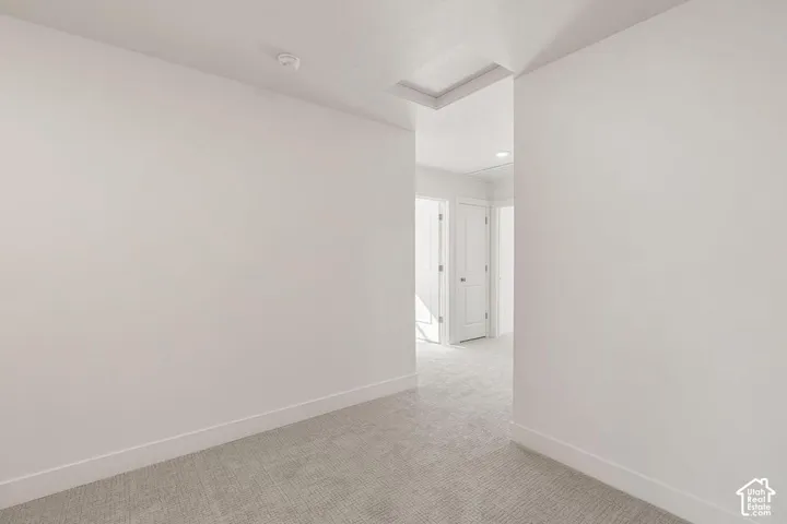 White walls with recessed lighting and a textured carpet