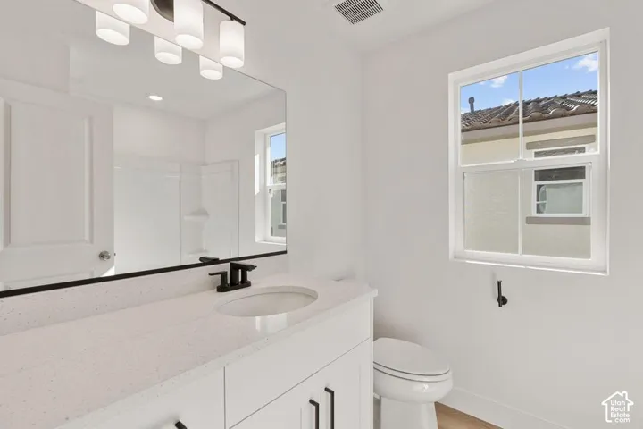 White vanity with an integrated sink, black hardware, and a large mirror