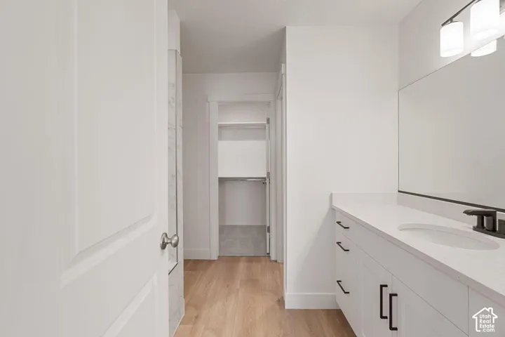 White vanity with a quartz countertop, integrated sink, and matte black hardware