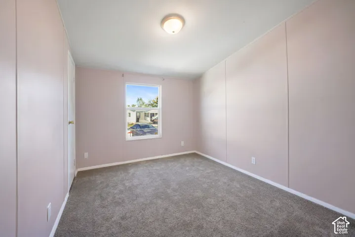Recessed ceiling light fixture, window with white trim, wall-to-wall carpeting, white interior door, and light-toned walls
