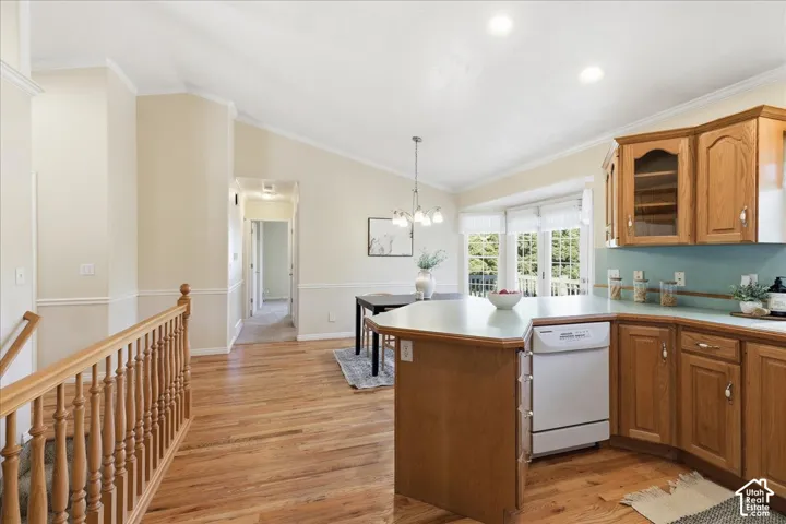 Kitchen featuring natural wood cabinetry, peninsula with solid surface countertop, wood-finish flooring, vaulted ceilings, and a bay window