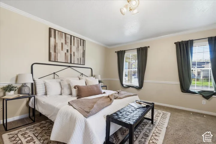 Primary suite. Neutral-toned interior space featuring crown molding, chair rail trim, two windows with adjustable blinds, and a multi-arm flush mount ceiling fixture