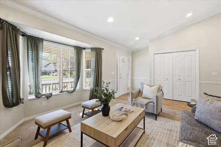 Vaulted ceilings featuring recessed lighting, a large bay window, and double-door entryway storage with a white-paneled finish