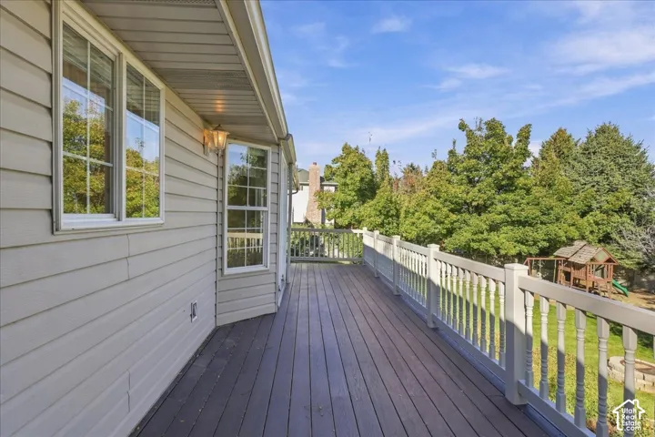 Elevated rear deck featuring horizontal siding, wood-finish decking, and balustraded railing