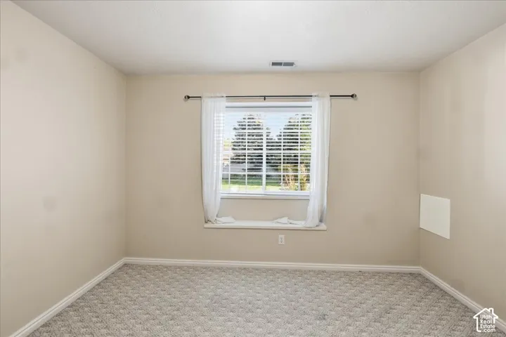 Bedroom #2. Interior room featuring neutral wall paint, carpeted flooring, and a window with a wide sill